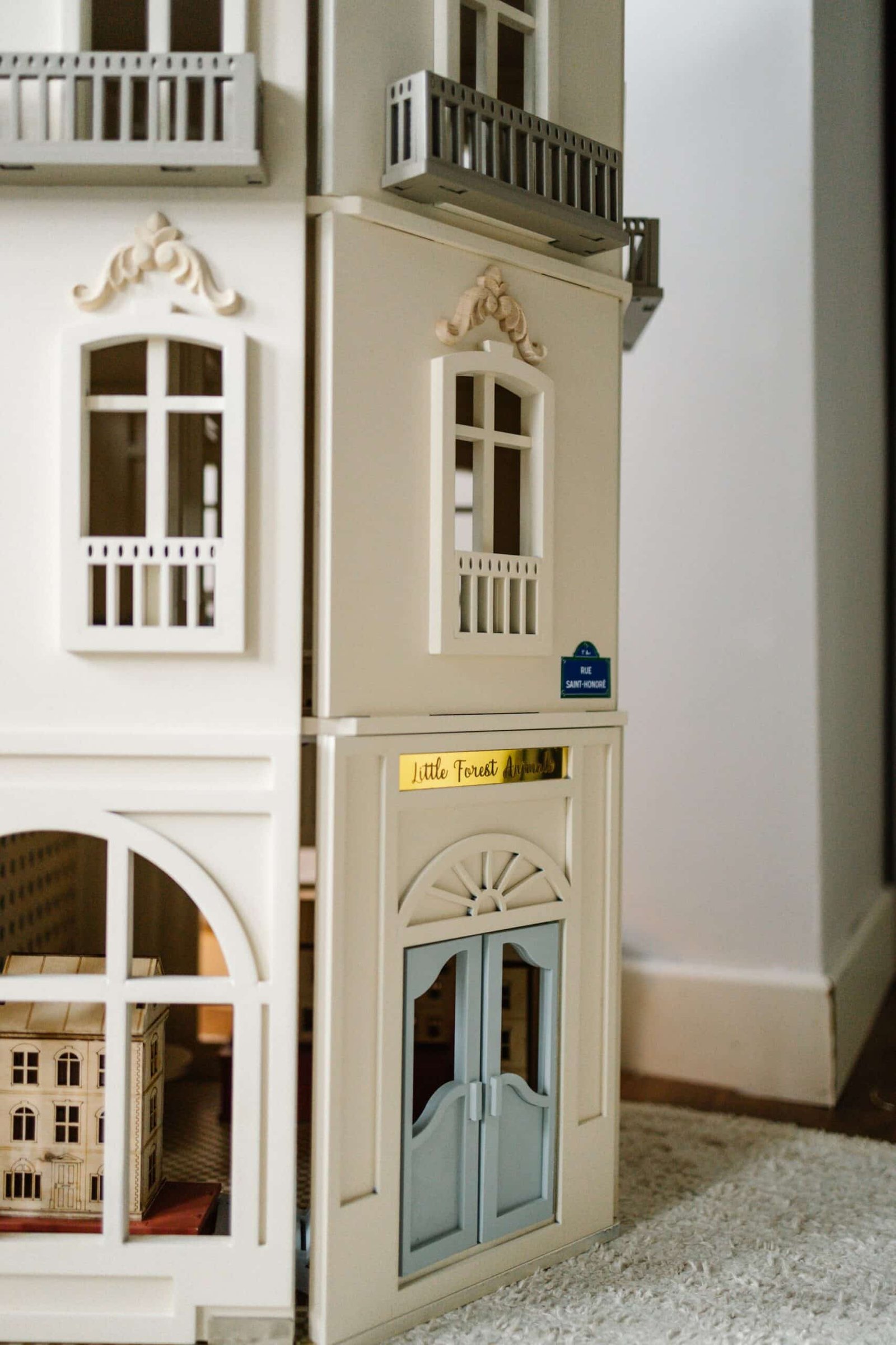 Paris Dollhouse – Four-Story Handcrafted Miniature Front view of the handcrafted four-story Paris Dollhouse featuring French architectural details and miniature storefront windows.