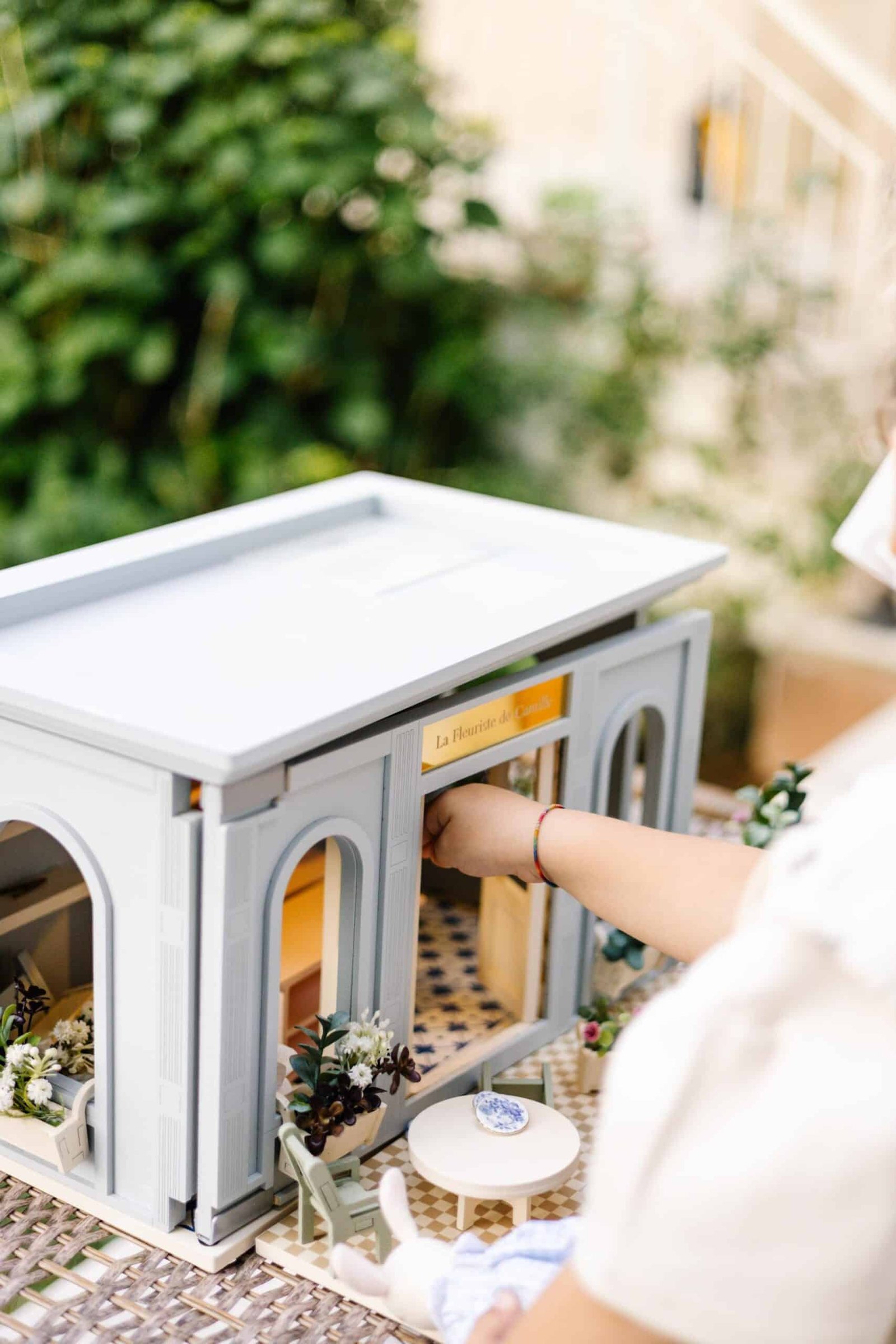 La Fleuriste de Camille – Wooden Flower Shop Dollhouse Miniature wooden flower shop dollhouse in pastel blue, with plants, a bunny figure, and charming outdoor details
