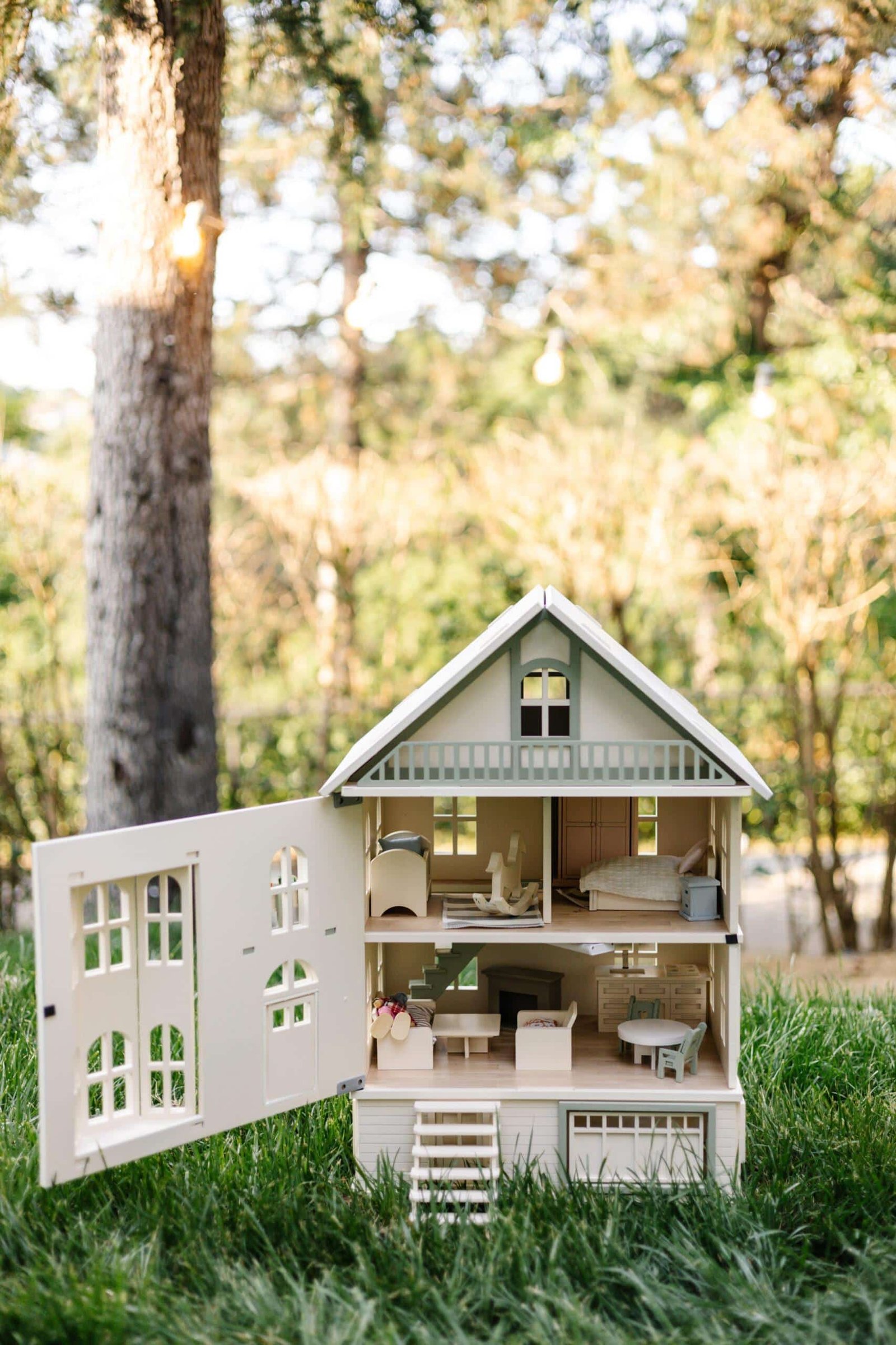 Victorian Wooden Dollhouse | Handcrafted by Little Forest Animals Victorian-style handcrafted white wooden dollhouse by Little Forest Animals, photographed outdoors on green grass in natural light.