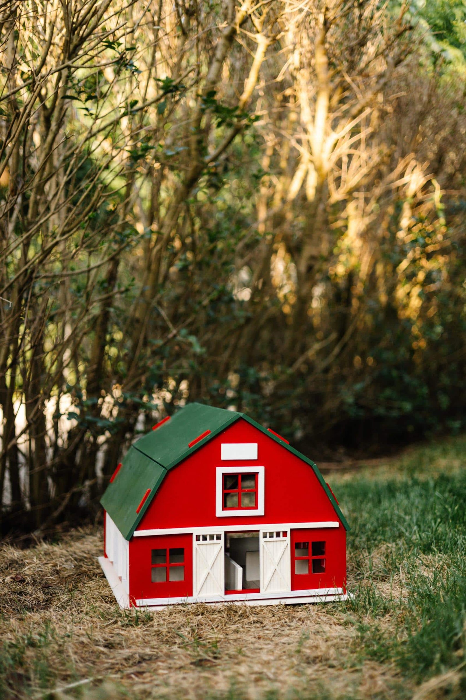 IMG_5748 2 Handcrafted red wooden barn-style dollhouse with green roof, designed by Little Forest Animals for sustainable and imaginative play.