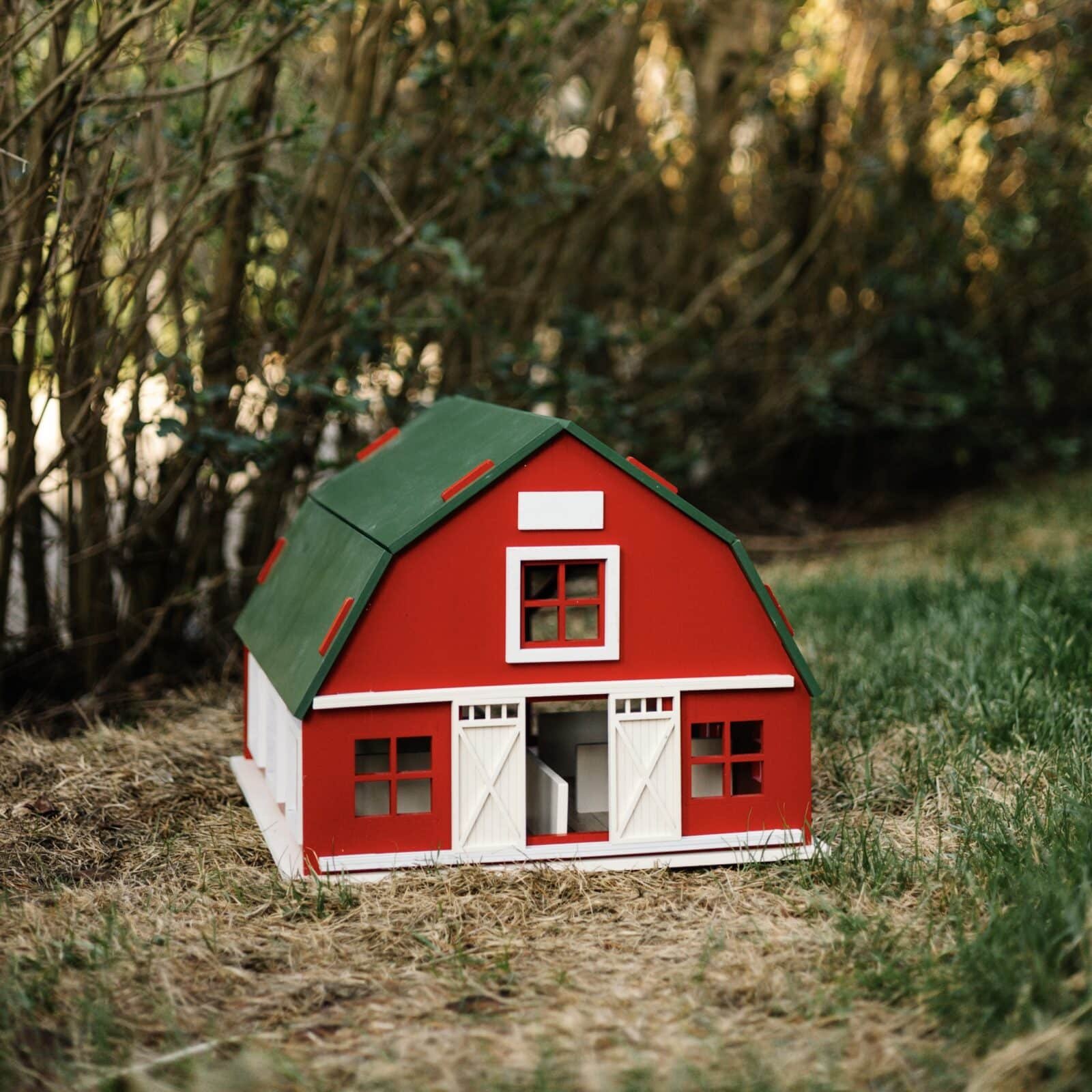 Handcrafted Barn-Style Wooden Dollhouse | Little Forest Animals Handcrafted red wooden barn-style dollhouse with green roof, designed by Little Forest Animals for sustainable and imaginative play.
