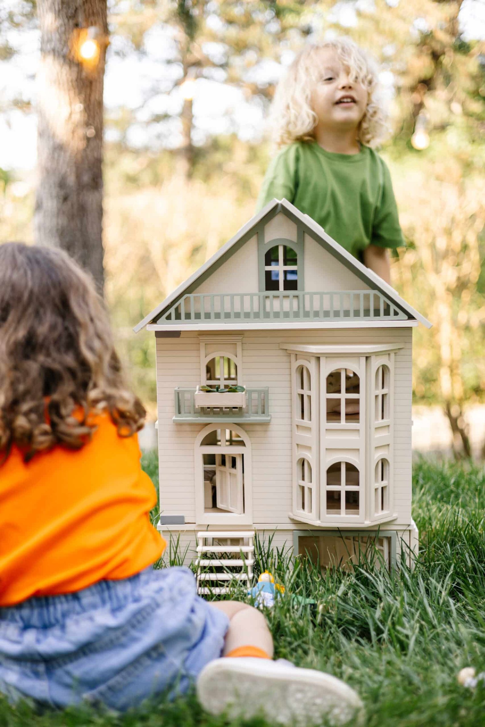 Victorian Wooden Dollhouse | Handcrafted by Little Forest Animals Victorian-style handcrafted white wooden dollhouse by Little Forest Animals, photographed outdoors on green grass in natural light.