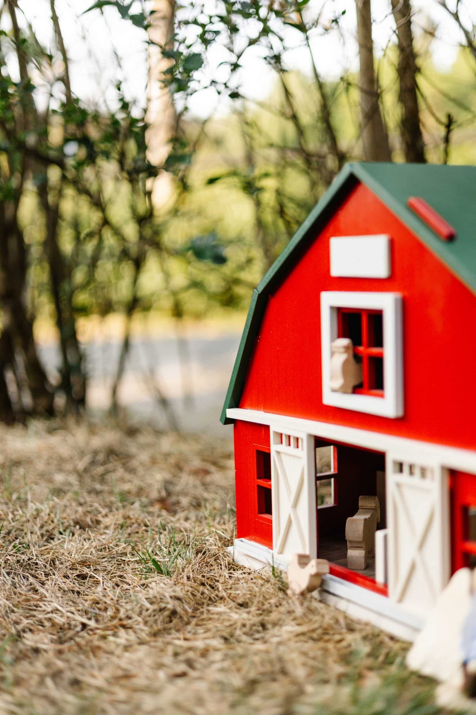 Handcrafted Barn-Style Wooden Dollhouse | Little Forest Animals Handcrafted red wooden barn-style dollhouse with green roof, designed by Little Forest Animals for sustainable and imaginative play.