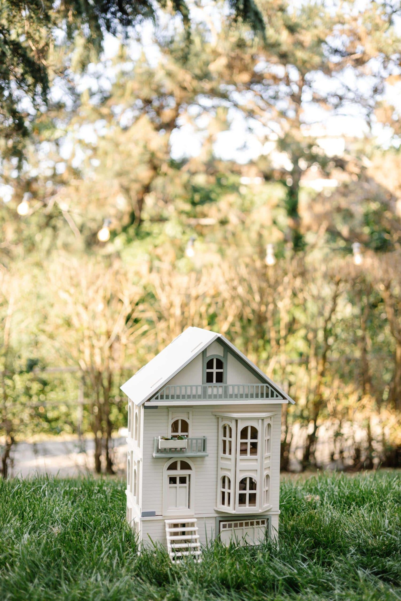 Victorian Wooden Dollhouse | Handcrafted by Little Forest Animals Victorian-style handcrafted white wooden dollhouse by Little Forest Animals, photographed outdoors on green grass in natural light.