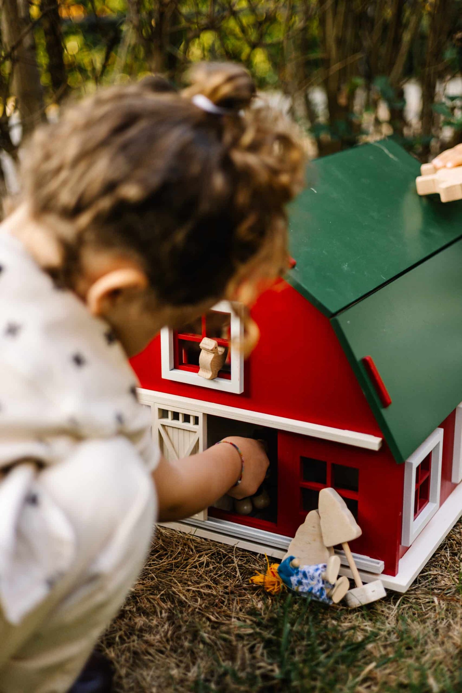 Handcrafted Barn-Style Wooden Dollhouse | Little Forest Animals Handcrafted red wooden barn-style dollhouse with green roof, designed by Little Forest Animals for sustainable and imaginative play.