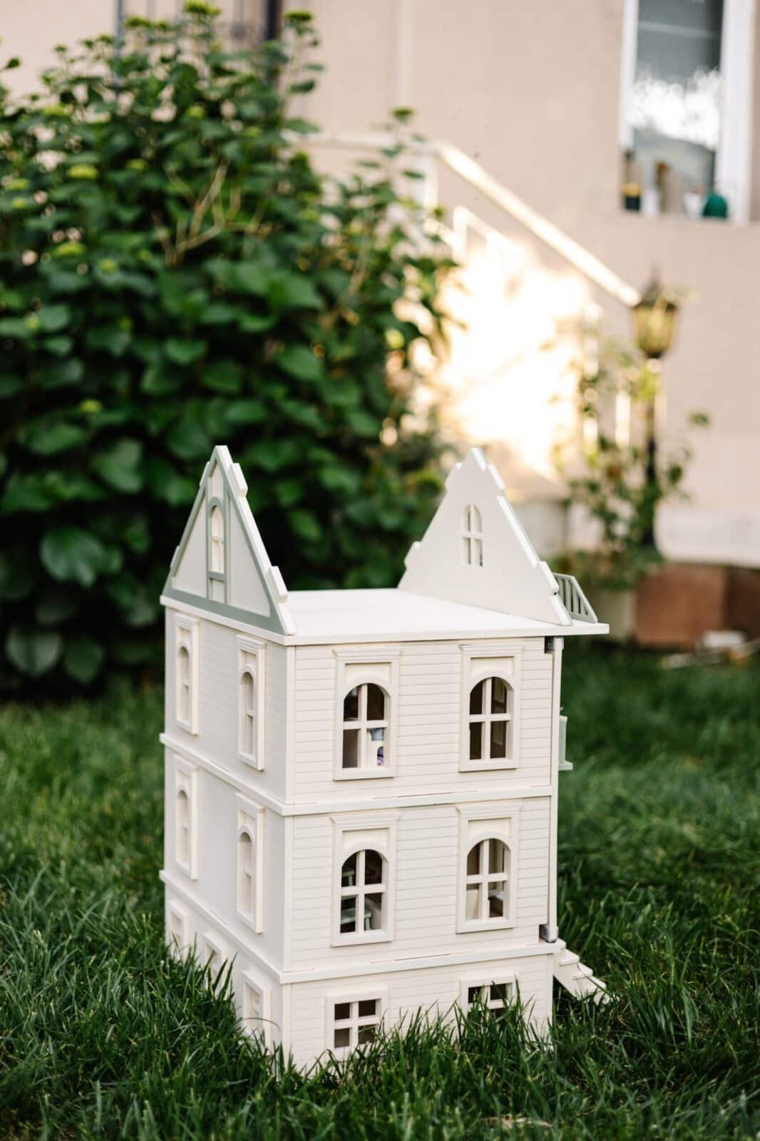 Victorian Wooden Dollhouse | Handcrafted by Little Forest Animals Victorian-style handcrafted white wooden dollhouse by Little Forest Animals, photographed outdoors on green grass in natural light.
